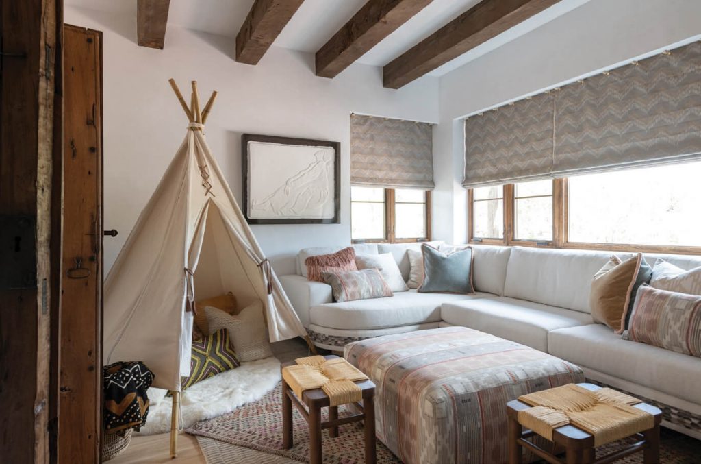 Nicknamed the “Saint’s Room” by its Santa Fe homeowners, this vibrant guest bedroom features a painted sun (in Sherwin-Williams Brittlebush) and several authentic retablos. The bed is covered in textiles from Isabelle de Borchgrave’s Fabricut collection. Photo: Michael Hunter